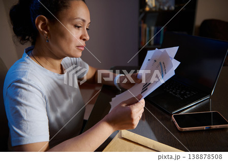 Woman Reviewing Financial Documents at Home Office Desk With Laptop and Smartphone Woman Reviewing Financial Documents at Home Office Desk With Laptop and Smartphone 138878508