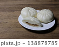 木材背景の皿にのせた肉まん 138878785