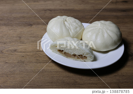 木材背景の皿にのせた肉まん 138878785