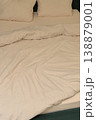 Soft white bedding with wrinkled duvet and two pillows on bed 138879001