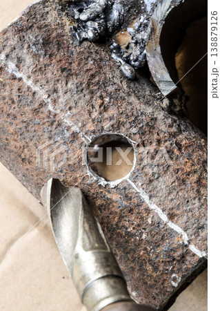 Drill for metal. A drilled hole in the steel part. 138879126