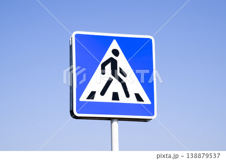 A pedestrian crossing sign. Sign on a blue sky background. A pedestrian crossing sign. Sign on a blue sky background. 138879537