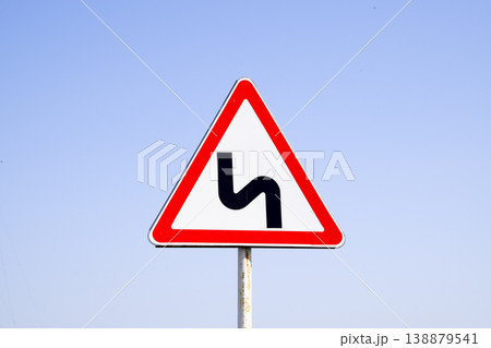 Road sign dangerous turn. Warning sign. 138879541