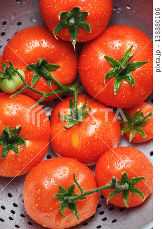 Top view of washed tomatoes in metal colander 138880106