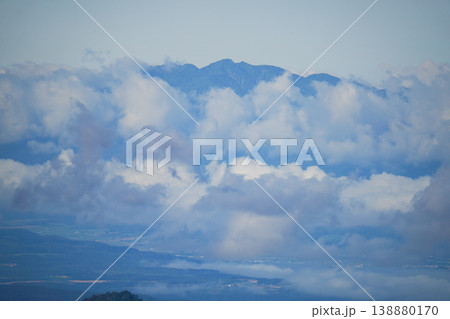 厚い雲から顔を出す北海道の山頂と平野の遠望。北海道の大自然を代表する絶景。北海道の雄大な自然美を捉え 厚い雲から顔を出す北海道の山頂と平野の遠望。北海道の大自然を代表する絶景。北海道の雄大な自然美を捉え 138880170