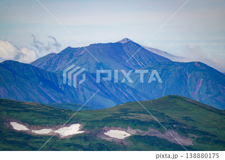 青い重層稜線と雪渓の北海道高山遠望。北海道の大自然を代表する絶景。北海道の雄大な自然美を捉えた風景写 青い重層稜線と雪渓の北海道高山遠望。北海道の大自然を代表する絶景。北海道の雄大な自然美を捉えた風景写 138880175