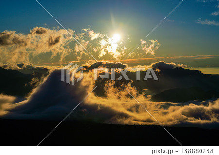 山岳と雲海の上に輝く太陽と雲のドラマ。山々の間に雲海が広がる幻想的な朝の情景。山間に広がる幻想的な雲 山岳と雲海の上に輝く太陽と雲のドラマ。山々の間に雲海が広がる幻想的な朝の情景。山間に広がる幻想的な雲 138880238