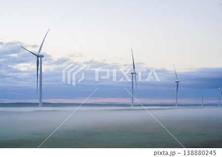 夜明けの濃い朝霧に浮かぶ北海道の複数の風力発電機。北海道の大自然を代表する絶景。再生可能エネルギーの 夜明けの濃い朝霧に浮かぶ北海道の複数の風力発電機。北海道の大自然を代表する絶景。再生可能エネルギーの 138880245