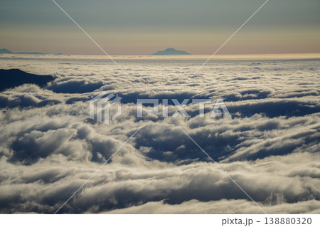 濃厚な雲海と背後に浮かぶ山頂。山々の間に雲海が広がる幻想的な朝の情景。山間に広がる幻想的な雲海と北海 濃厚な雲海と背後に浮かぶ山頂。山々の間に雲海が広がる幻想的な朝の情景。山間に広がる幻想的な雲海と北海 138880320