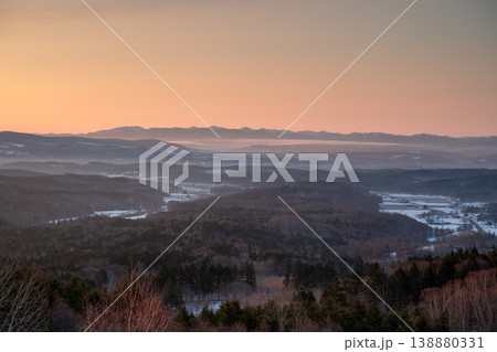 ピンクの夕焼けと雪の谷・北海道冬の山岳パノラマ。北海道の大自然を代表する絶景。北海道の雄大な自然美を ピンクの夕焼けと雪の谷・北海道冬の山岳パノラマ。北海道の大自然を代表する絶景。北海道の雄大な自然美を 138880331