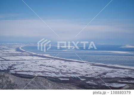 雪の農地が海まで続く冬の俯瞰風景。北海道の大自然を代表する絶景。再生可能エネルギーの風力発電と北海道 雪の農地が海まで続く冬の俯瞰風景。北海道の大自然を代表する絶景。再生可能エネルギーの風力発電と北海道 138880379