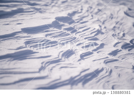 風で造形された冬の雪面パターン。北海道の大自然を代表する絶景。再生可能エネルギーの風力発電と北海道の 風で造形された冬の雪面パターン。北海道の大自然を代表する絶景。再生可能エネルギーの風力発電と北海道の 138880381