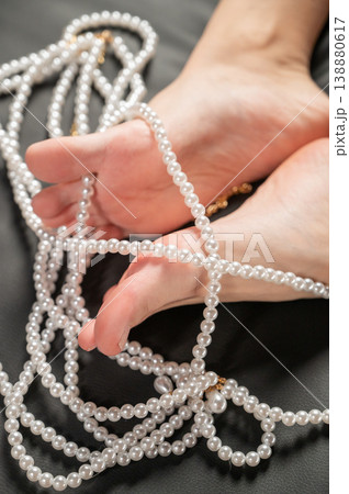 Foot fetish. Bare female feet with pearl beads. Foot fetish. Bare female feet with pearl beads. 138880617