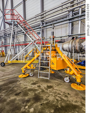 Yellow industrial mobile access platforms for aircraft engine maintenance, repair, and overhaul (MRO) in a service hangar. Aviation industry equipment. . High quality photo Yellow industrial mobile access platforms for aircraft engine maintenance, repair, and overhaul (MRO) in a service hangar. Aviation industry equipment. . High quality photo 138881409