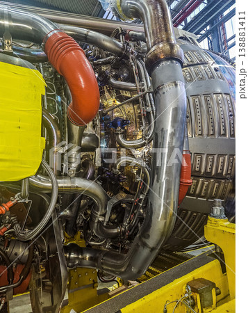The intricate mechanics and complex network of pipes, tubes, and wires on a powerful jet turbine. Aviation technology and engineering concept. . High quality photo The intricate mechanics and complex network of pipes, tubes, and wires on a powerful jet turbine. Aviation technology and engineering concept. . High quality photo 138881411