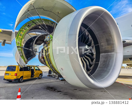 Detailed view of a huge aircraft turbine engine being serviced. A yellow maintenance van is parked nearby. Aviation industry and technology concept.. High quality photo 138881412