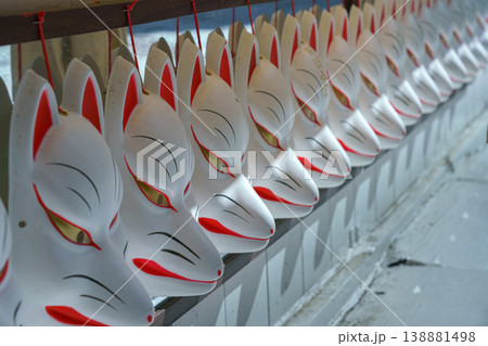Kyoto, Japan - Oct 11 2024, A close-up to a row of white souvenir masks of Japanese kitsune foxes, Kyoto, Japan 138881498