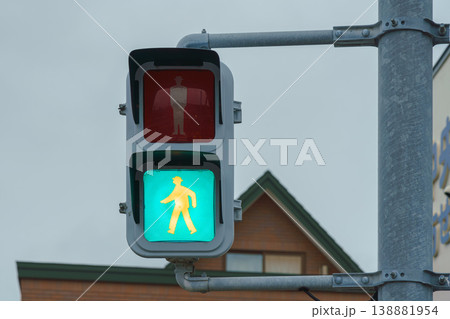 Muroran, Hokkaido, Japan - Oct 04 2024, close up view of a pedestrian traffic light with a green permit light on, at daytime, Muroran, Japan Muroran, Hokkaido, Japan - Oct 04 2024, close up view of a pedestrian traffic light with a green permit light on, at daytime, Muroran, Japan 138881954