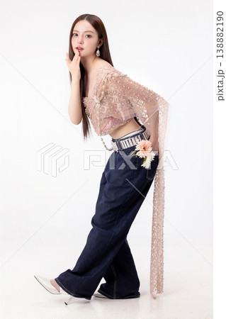 Modern trendy Thai fashion woman wearing a traditional Sabai paired with denim jeans, reflecting the growing fashion trend in Thailand that blends cultural heritage with contemporary street style. Modern trendy Thai fashion woman wearing a traditional Sabai paired with denim jeans, reflecting the growing fashion trend in Thailand that blends cultural heritage with contemporary street style. 138882190