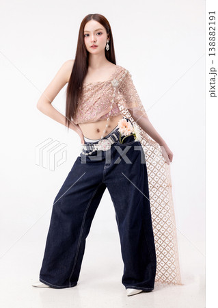 Modern trendy Thai fashion woman wearing a traditional Sabai paired with denim jeans, reflecting the growing fashion trend in Thailand that blends cultural heritage with contemporary street style. 138882191