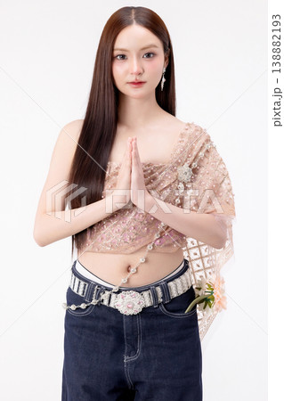 Modern trendy Thai fashion woman wearing a traditional Sabai paired with denim jeans, reflecting the growing fashion trend in Thailand that blends cultural heritage with contemporary street style. 138882193