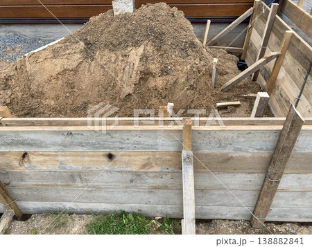 Construction site shows dirt pile in wooden frame ready for building Construction site shows dirt pile in wooden frame ready for building 138882841