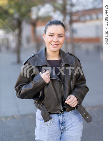 Young female tourist walks through a spring city and takes in sights Young female tourist walks through a spring city and takes in sights 138884425