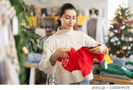Happy young Armenian girl choosing red panties in clothing store Happy young Armenian girl choosing red panties in clothing store 138884426