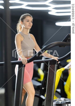 Young woman doing cardio exercises on treadmill Young woman doing cardio exercises on treadmill 138884431