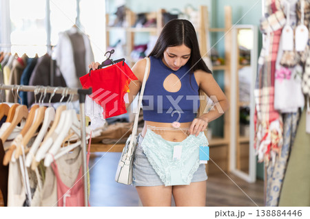 Young woman chooses panties in clothing store Young woman chooses panties in clothing store 138884446
