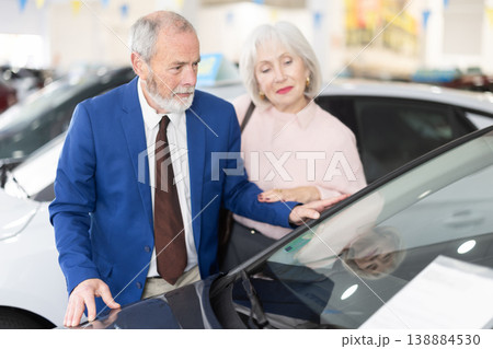 Elderly couple chooses new car together at car dealership Elderly couple chooses new car together at car dealership 138884530