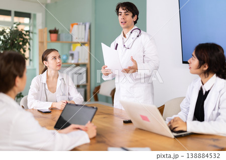 Young male doctor leading medical meeting in office Young male doctor leading medical meeting in office 138884532