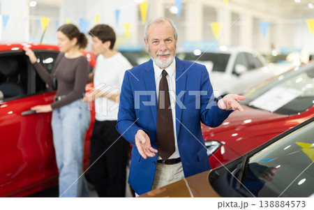 Elderly successful car salesman offers to buy a car at car dealership Elderly successful car salesman offers to buy a car at car dealership 138884573