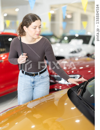 woman choosing a car in a car dealership woman choosing a car in a car dealership 138884584