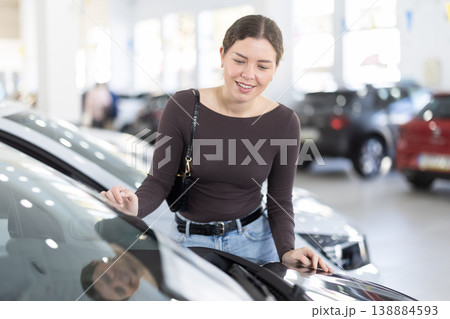 Young woman choosing car at auto dealership Young woman choosing car at auto dealership 138884593