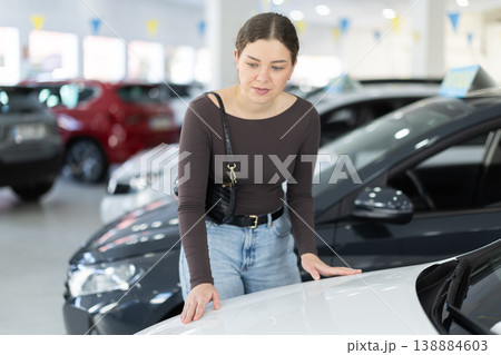 woman choosing a car in a car dealership woman choosing a car in a car dealership 138884603