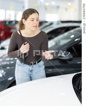 woman choosing a car in a car dealership woman choosing a car in a car dealership 138884799