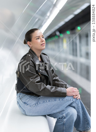 Portrait of pretty girl sitting on bench waiting for subway train 138884824