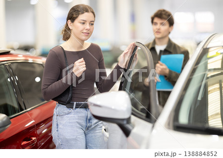 Young couple in a car dealership chooses a car 138884852