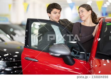 Young couple choosing car at auto dealership Young couple choosing car at auto dealership 138884898
