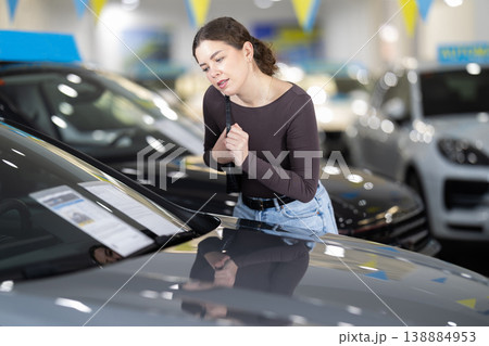 Young woman choosing car at auto dealership Young woman choosing car at auto dealership 138884953