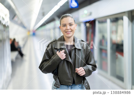 Pretty girl walks along the platform waiting for subway train 138884986
