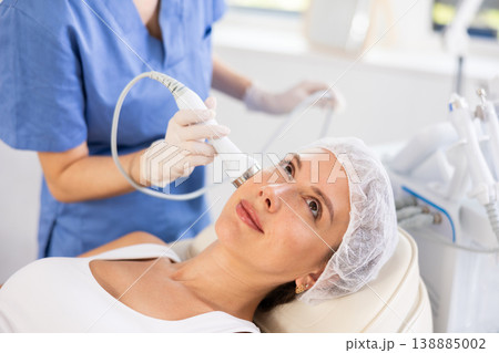 Young woman undergoing cosmetic high frequency ultrasound facial treatment 138885002