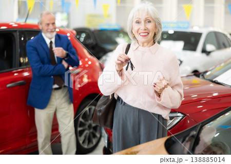 Senior woman is happy with a set of keys and the purchase of a new car Senior woman is happy with a set of keys and the purchase of a new car 138885014