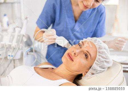 Young woman undergoing facial cleansing procedure using ultrasonic shovel 138885033