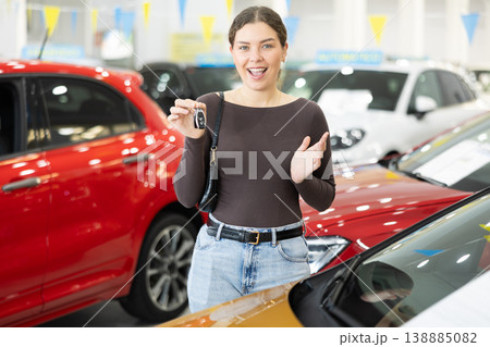 Young woman is happy to buy a car, she keeps the keys Young woman is happy to buy a car, she keeps the keys 138885082