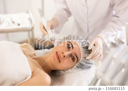 Young woman getting cosmetic facial procedure using ion bubble pen Young woman getting cosmetic facial procedure using ion bubble pen 138885115