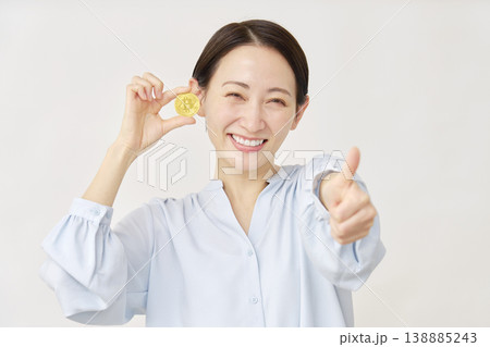 ビットコインを持つ40代の女性 グッドサイン 白背景 ビットコインを持つ40代の女性 グッドサイン 白背景 138885243