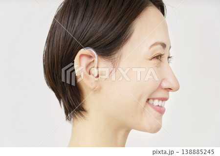 補聴器を使う40代の女性　白背景 138885245