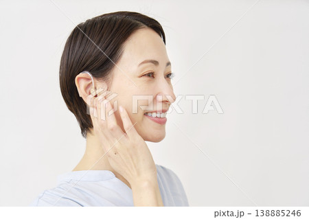 補聴器を使う40代の女性　白背景 138885246